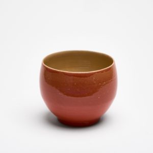 Handgemachte runde Steinzeugtasse in Koralle, innen naturfarben glasiert.
