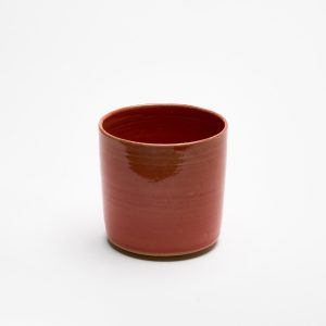 Handgefertigte rote Steinzeugtasse – minimalistische Keramik, von oben fotografiert.