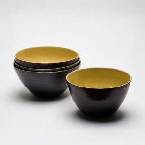 Handgemachte Steinzeugschalen im 4er-Set, außen dunkel und innen gelb glasiert.