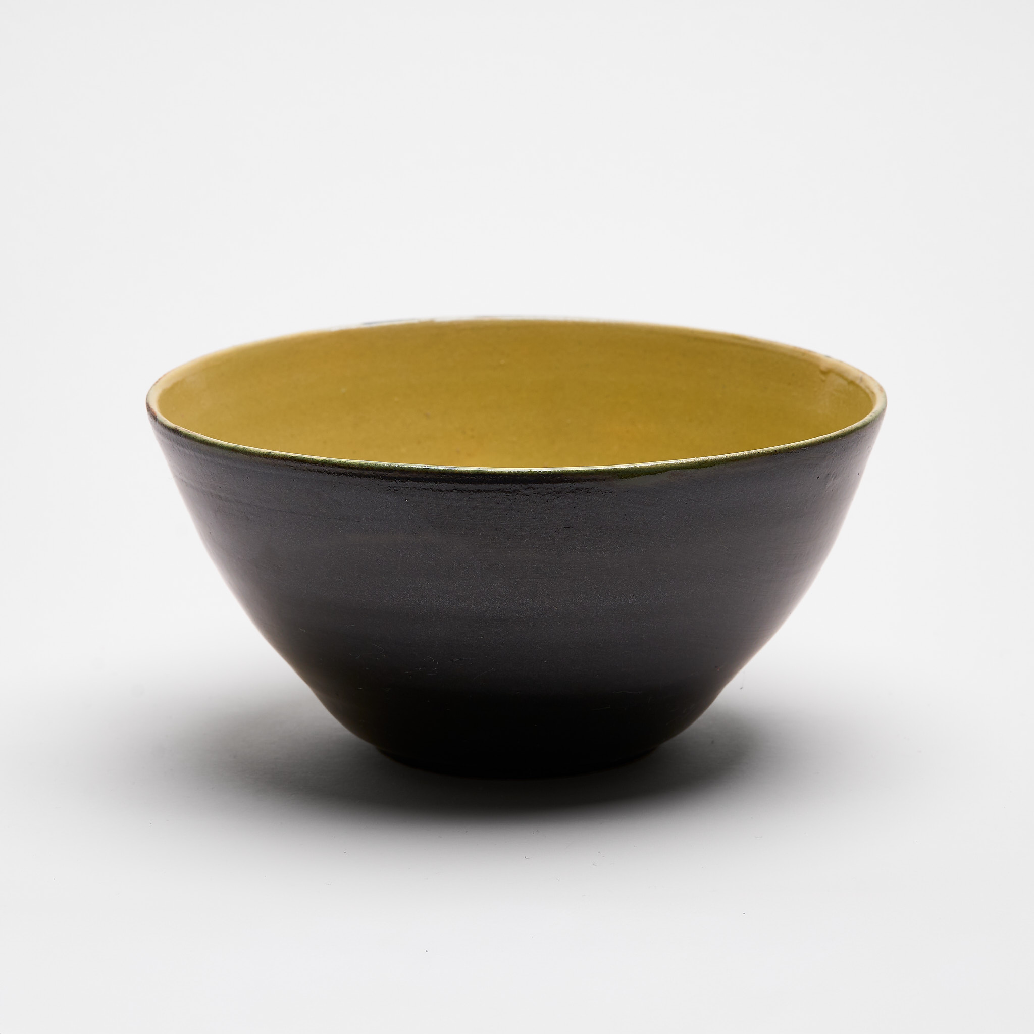 Handgefertigte Keramikschale mit schwarzer Aussenseite und gelber Innenglasur